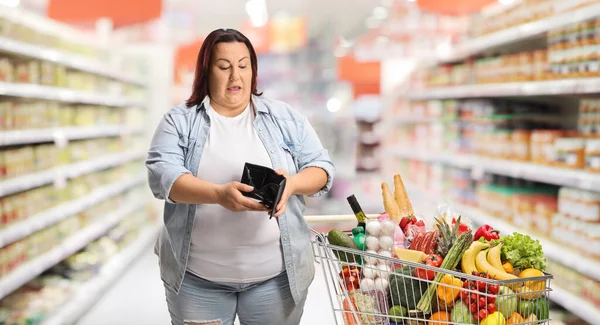 Corpulent Woman Shopping Cart Looking Empty Wallet Supermarket — Stock Photo, Image