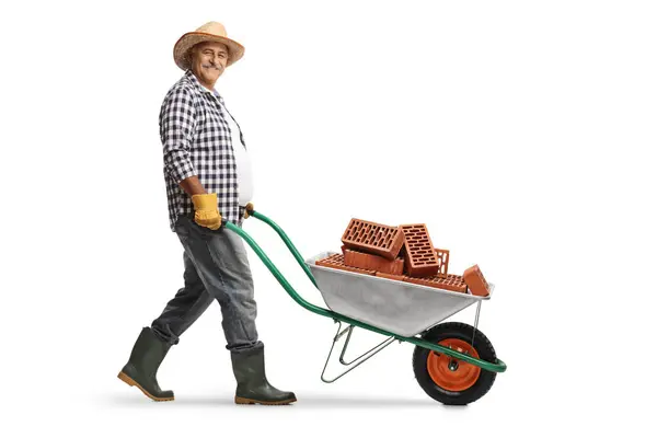Full Length Profile Shot Mature Gardener Pushing Wheelbarrow Bricks Isolated — Stock Photo, Image