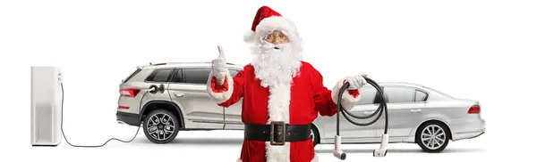 圣诞老人爪 电动车上装有充电器 并在白色背景下将大拇指伸出来做手势 — 图库照片