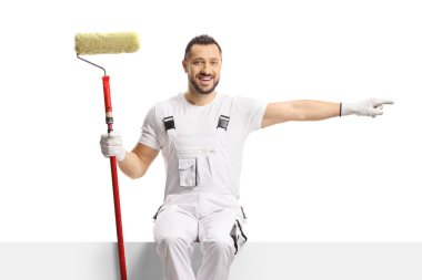 Boya silindirli bir ressam boş bir panele oturmuş ve beyaz arka planda izole edilmiş tarafı işaret ediyor.