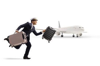 Beyaz arka planda izole edilmiş bir uçağın önünde bavulla koşan bir pilotun tam boy profil çekimi.