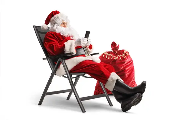 Père Noël Assis Dans Une Chaise Pliable Utilisant Smartphone Isolé — Photo