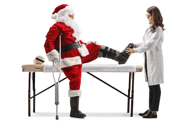 Médica Verificando Papai Noel Com Uma Cinta Muleta Isolada Fundo — Fotografia de Stock