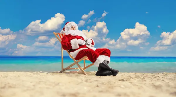 圣诞老人坐在海滩上的椅子上 在海边休息 — 图库照片