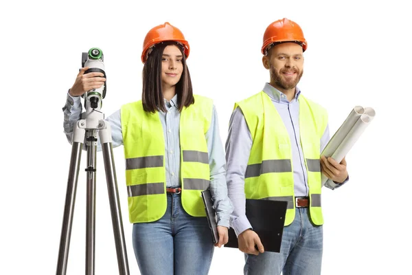 Kvinnlig Geodetisk Lantmätare Med Mätanordning Och Manlig Ingenjör Som Poserar — Stockfoto