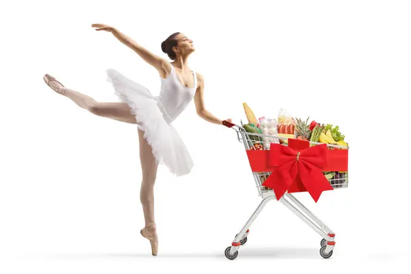 跳芭蕾的舞者穿着白色的燕尾服跳舞 推着一辆红色缎带蝴蝶结的购物车 背景与白色格格不入 — 图库照片