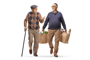 Bastonlu yaşlı bir adam beyaz arka planda izole edilmiş alışveriş torbalarıyla yürüyor ve konuşuyor.