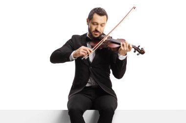 Kemancı boş bir panelde oturuyor ve beyaz arka planda izole edilmiş bir keman çalıyor. 