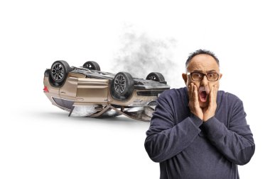 Shocked mature man watching a car tumbling isolated on white background clipart