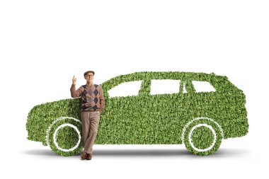Yeşil elektrikli bir araca yaslanan ve beyaz arka planda izole edilmiş yaşlı bir adam.