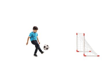 Küçük bir çocuğun beyaz arka planda izole edilmiş mini bir golle futbol oynadığı uzun bir çekim.