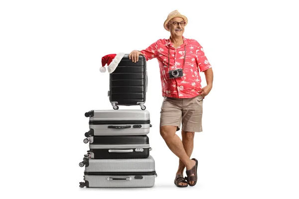 成熟した男は 白い背景に隔離されたクリスマスの休暇の準備をするスーツケースに傾いています — ストック写真