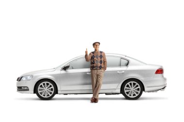 Gümüş bir arabaya yaslanmış yaşlı bir adam ve beyaz arka planda izole edilmiş işaret parmakları.