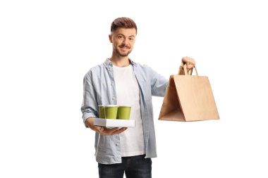 Elinde paket kahve ve beyaz arka planda izole edilmiş bir kese kağıdı tutan genç adam.