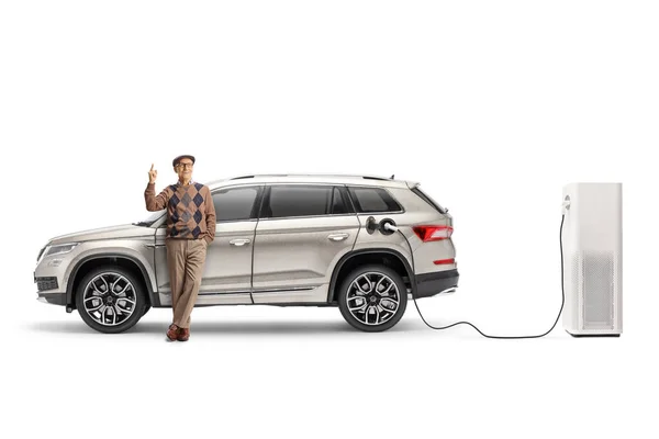 Elderly Man Leaning Electric Suv Charging Point Pointing Isolated White — Stock Photo, Image