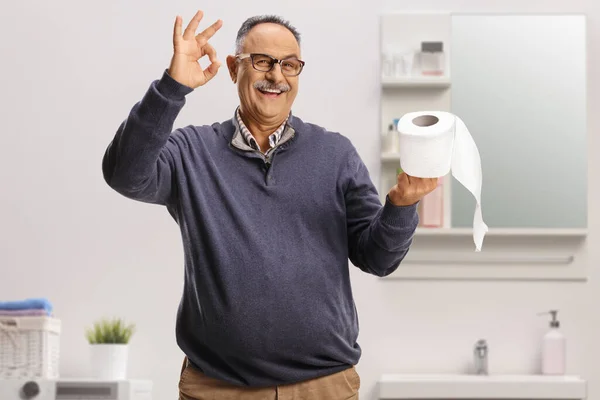 Gülümseyen Olgun Bir Adam Tuvalet Kağıdı Rulosu Tutuyor Tuvalette Işaret — Stok fotoğraf