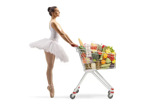 白い背景に隔離されたショッピングカートで食べ物を待っているバレリーナのフル長さのプロフィールショット — ストック写真