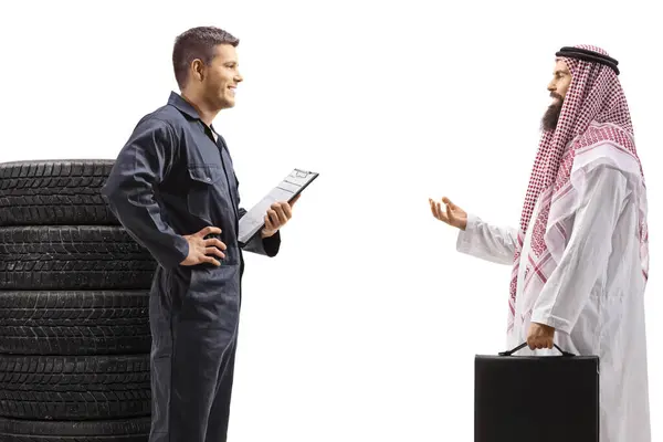 一名汽车修理工和一名男性阿拉伯裔顾客在白色背景下与外界隔离交谈时的侧面照片 — 图库照片