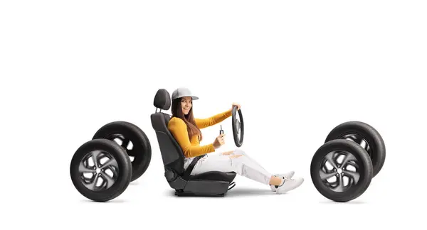 白い背景に隔離された4つの車輪の車の座席のキーを握っている若い女性 — ストック写真