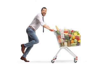 Excited man running with a shopping cart and smiling at camera isolated on white background