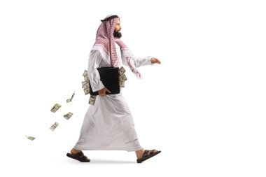 Full length profile shot of a suadi arab man walking with a briefcase full of money isolated on white background