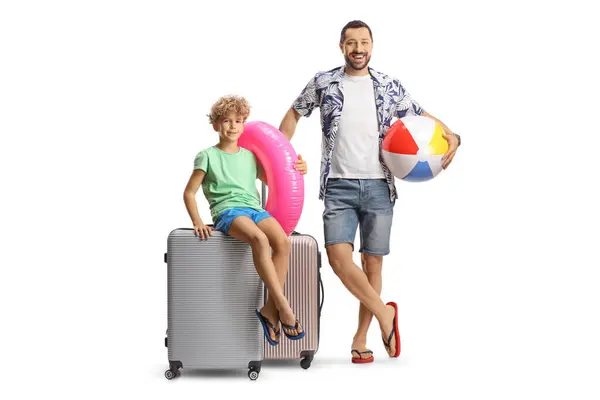 スーツケースを持った父と息子が微笑み ビーチボールと水泳リングを白い背景に隔離しました — ストック写真