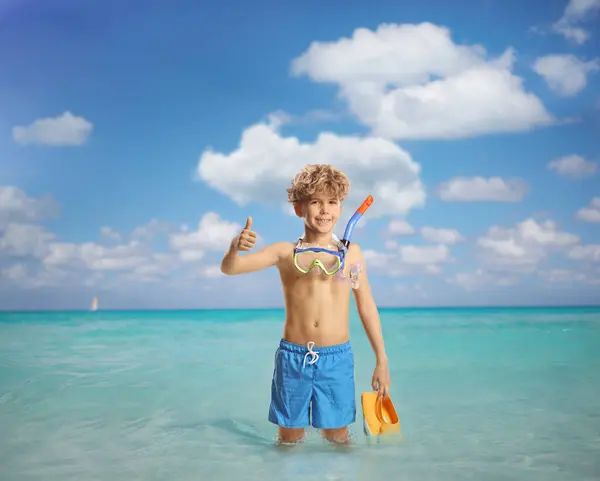 小孩拿着潜水面具站在海里 竖起大拇指做手势 — 图库照片