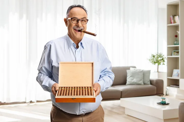 Starší Muž Kouří Doma Doutník Drží Krabici Doutníků — Stock fotografie