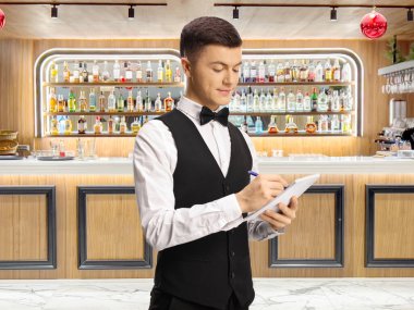 Bir barın önünde duran papyonlu genç bir erkek garson.