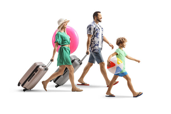 Full length profile shot of a mother, father and son with suitcases going on a summer holiday isolated on white background
