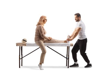 Terapist, beyaz arka planda soyutlanmış bir kadına ayak masajı yapıyor.