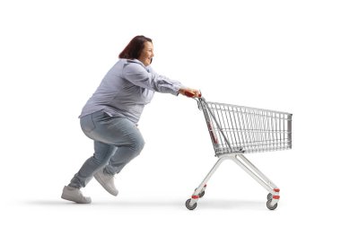 Beyaz arka planda boş bir alışveriş arabasıyla koşan şişman bir kadının profil fotoğrafı.