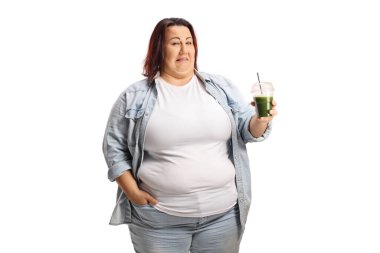 Beyaz arka planda izole edilmiş yeşil bir smoothie tutan iğrenç genç kadın.