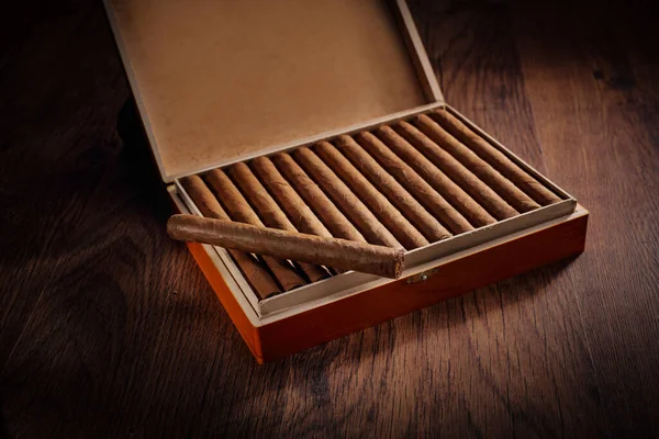 深褐色木地板上的一盒古巴雪茄 — 图库照片
