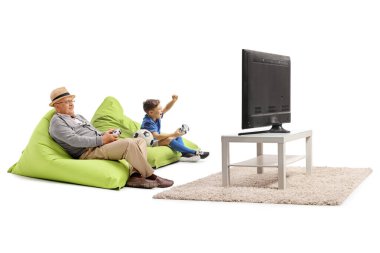 Torun ve büyükbaba beyaz arka planda izole edilmiş joysticklerle futbol oynuyorlar.