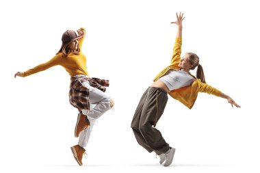 Beyaz arka planda yalnız dans eden iki genç kadının tam boy çekimi.