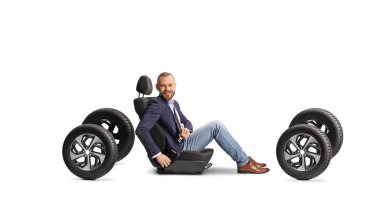 Araba koltuğunda emniyet kemeri olan ve beyaz arka planda izole edilmiş kameraya gülümseyen yolcu.