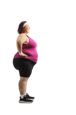 Beyaz arka planda izole edilmiş spor giyimli, geniş beden bir kadının tam boy profil çekimi.