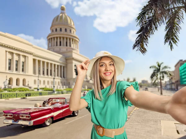 在古巴哈瓦那的El Capitolio大楼前 戴着草帽的快乐的年轻女子正在自拍 — 图库照片