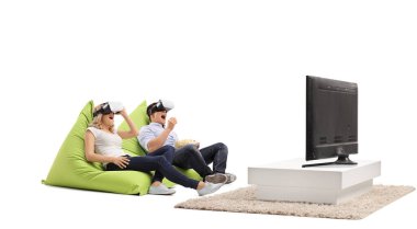 Beyaz arka planda sanal gerçeklik kulaklıklarıyla televizyon izleyen heyecanlı genç çift