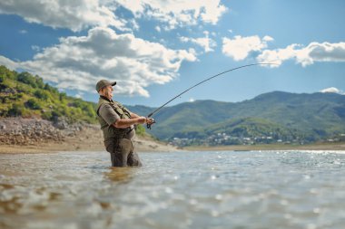 Dağ gölünde balık tutan balıkçı