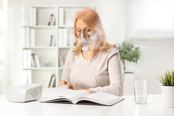 Evde Nebulizör Kullanan Bir Kadın Kitap Okuyor — Stok fotoğraf