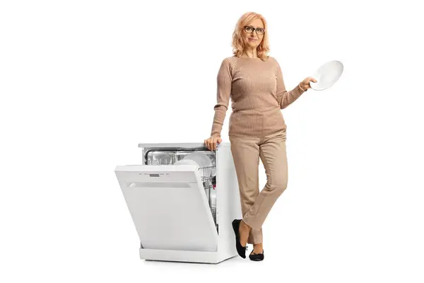 Mulher Meia Idade Segurando Prato Branco Limpo Lado Uma Máquina — Fotografia de Stock