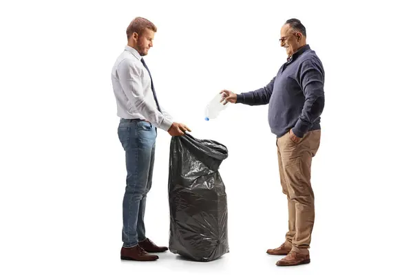 Mature Man Throwing Plastic Bottle Black Waste Bag Held Younger — Stock Photo, Image