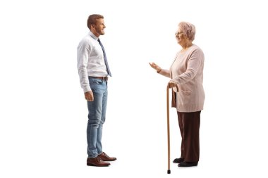 Beyaz arka planda izole edilmiş kot ve beyaz gömlekli bir adamla konuşan yaşlı bir kadın.