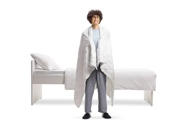 Young Man Pajamas Wrapped Blanket Standing Next His Bed Isolated — Stock Photo, Image