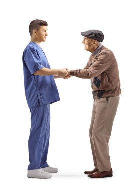 Genç doktor yaşlı bir hastaya destek veriyor ve ellerini beyaz arka planda tutuyor.