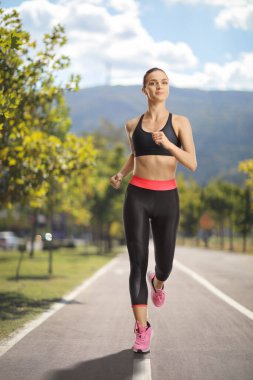 Parkta koşan sağlıklı genç bir kadın.