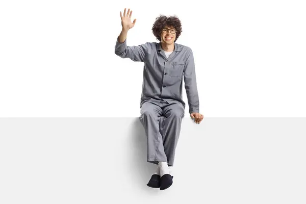 Young Man Pajamas Slippers Sitting Blank Panel Waving Isolated White — Stock Photo, Image