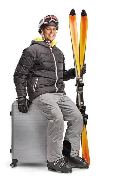 Jongeman Winterjas Met Een Paar Ski Zittend Een Koffer Geïsoleerd — Stockfoto
